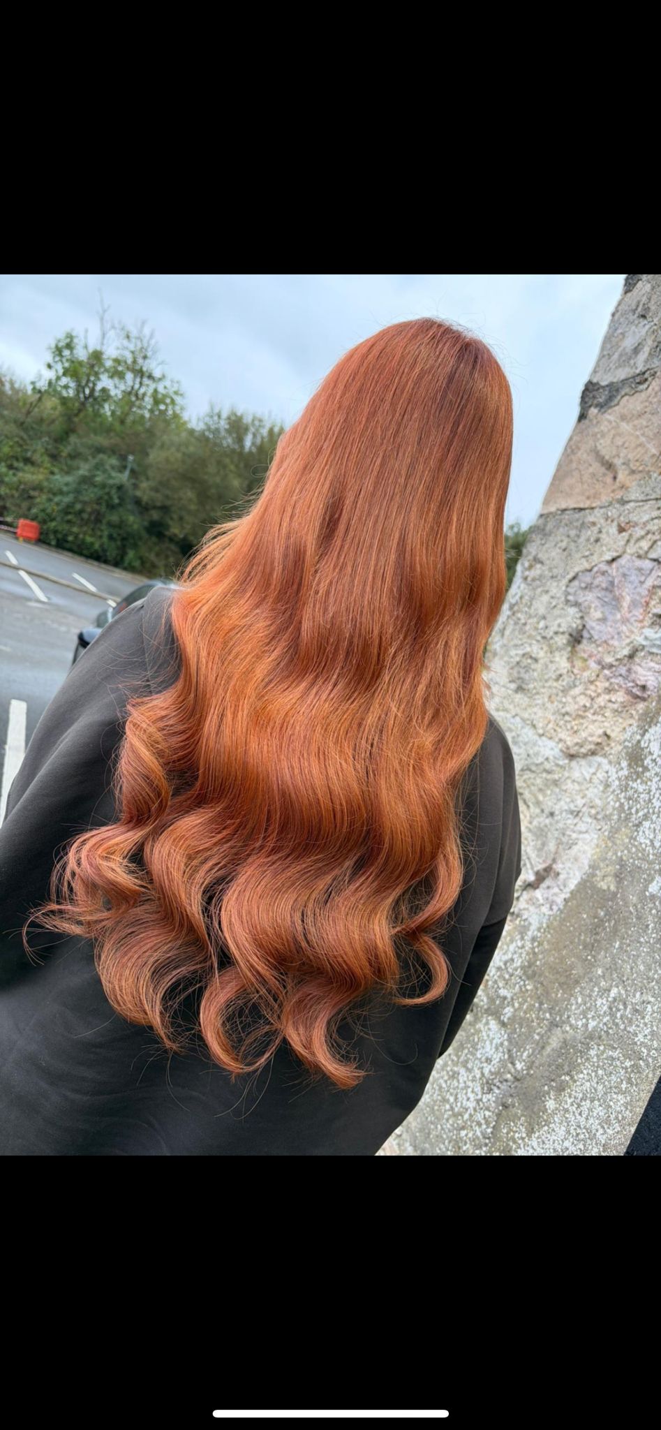 Client with vibrant copper hair styled in bouncy waves
